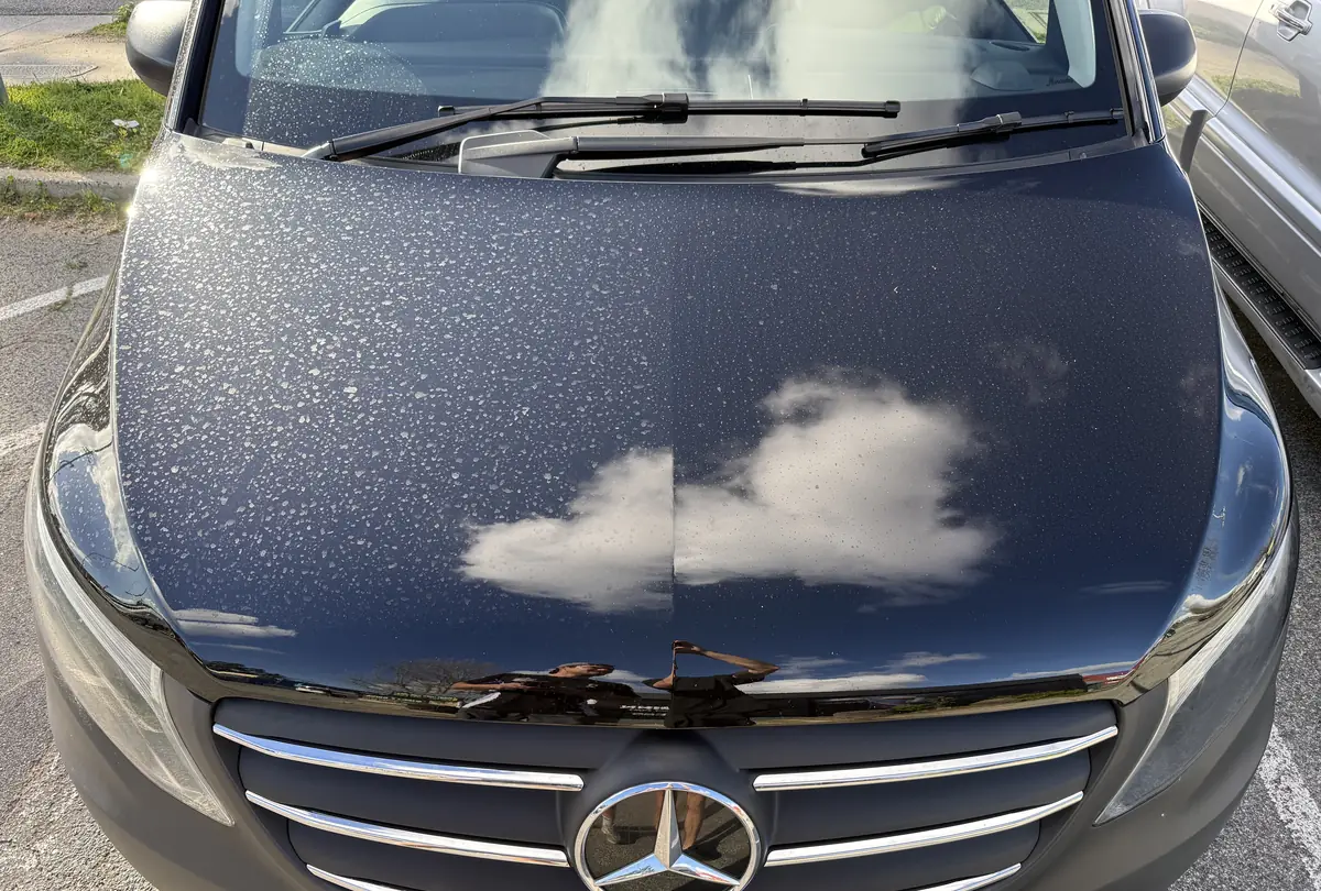 Rain beading on the ceramic coated black bonnet of the Aurex work van